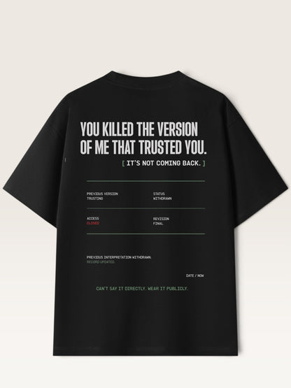 Black - short-sleeve t-shirt shown from the back, featuring a white typographic graphic with text and a minimalist terminal-style design on a light beige background.