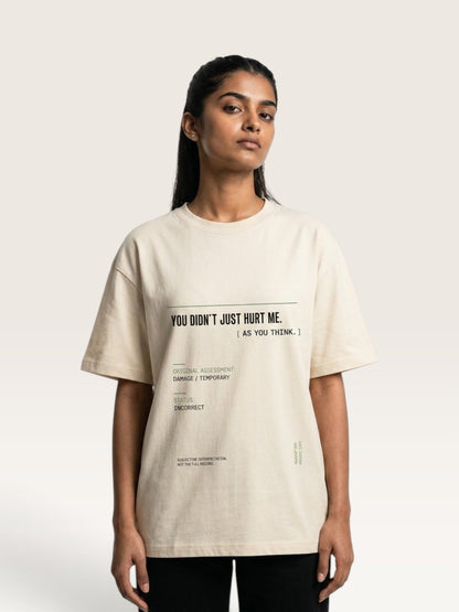 Mild Apricot - A woman modeling a cream-colored oversized graphic t-shirt with black text that reads 'YOU DIDN'T JUST HURT ME. [ AS YOU THINK.