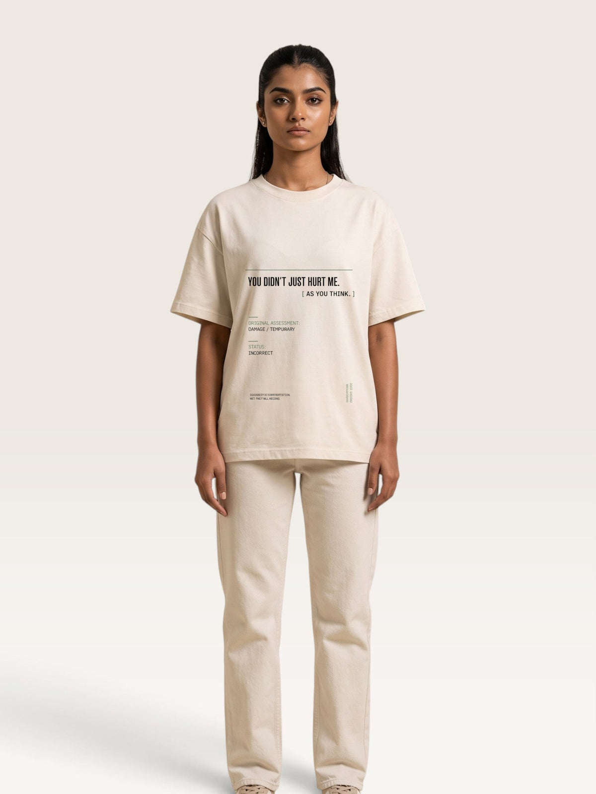 Mild Apricot - model stands against a light beige studio background wearing a cream-colored oversized t-shirt with black text and matching cream-colored wide-leg trousers.