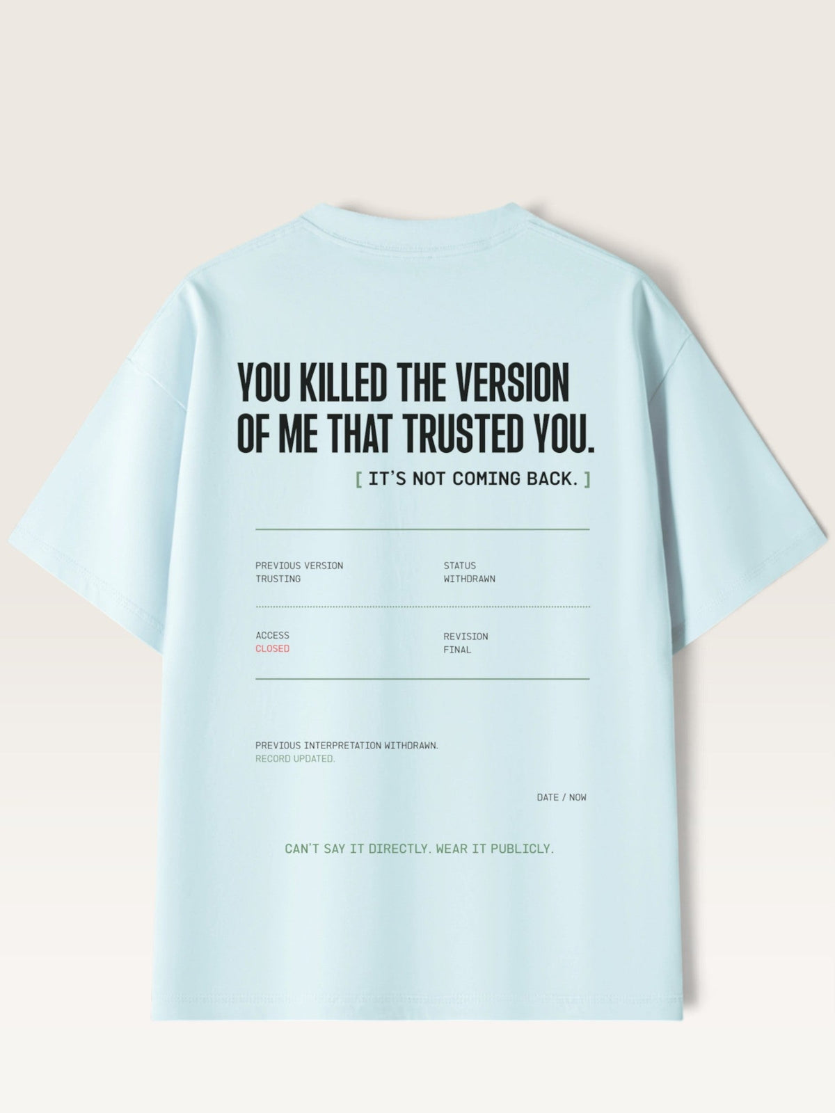 Sky Blue - A light blue short-sleeve t-shirt shown from the back, featuring a humorous text graphic in black and small gray and green details on a light beige background.