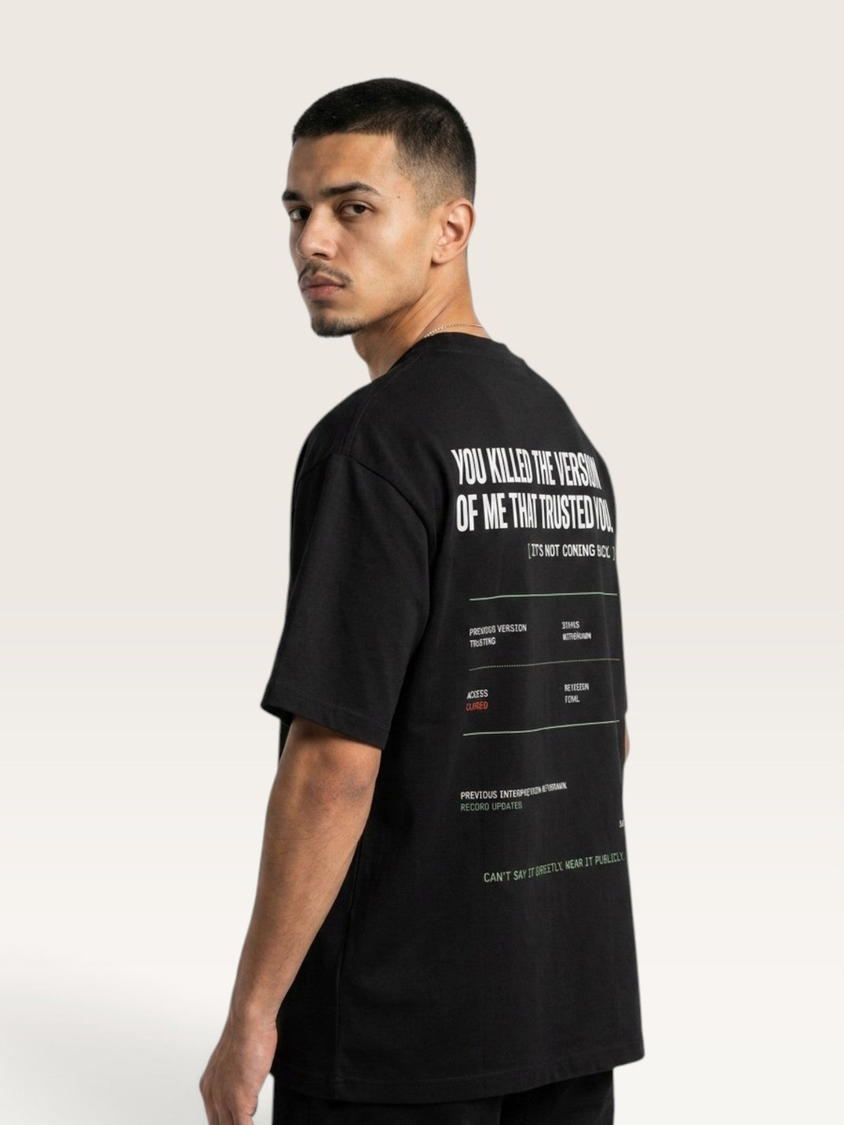 Black - short-sleeve t-shirt shown from the back, featuring a white typographic graphic with text and a minimalist terminal-style design on a light beige background.
