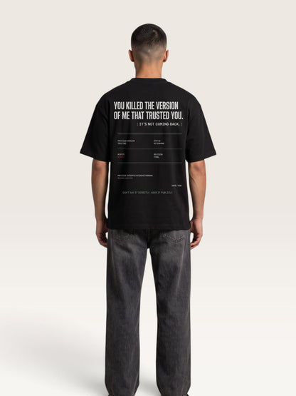 Black - short-sleeve t-shirt shown from the back, featuring a white typographic graphic with text and a minimalist terminal-style design on a light beige background.