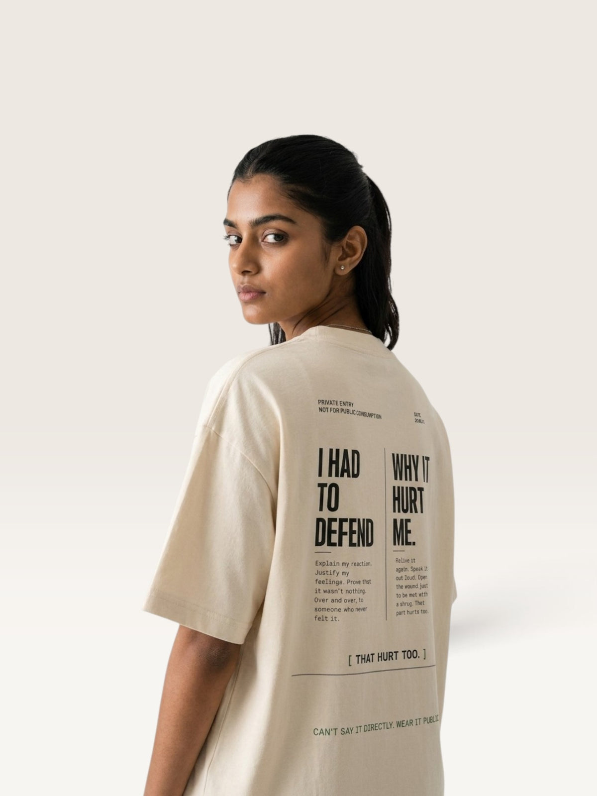 Mild Apricot WEARCAPTION oversized beige heavyweight cotton t-shirt with black typographic back print worn by a woman