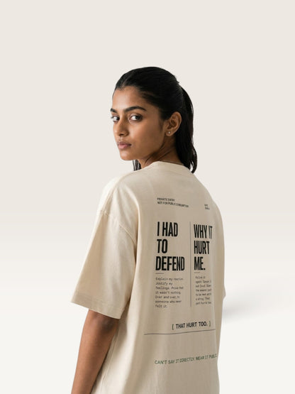 Mild Apricot WEARCAPTION oversized beige heavyweight cotton t-shirt with black typographic back print worn by a woman