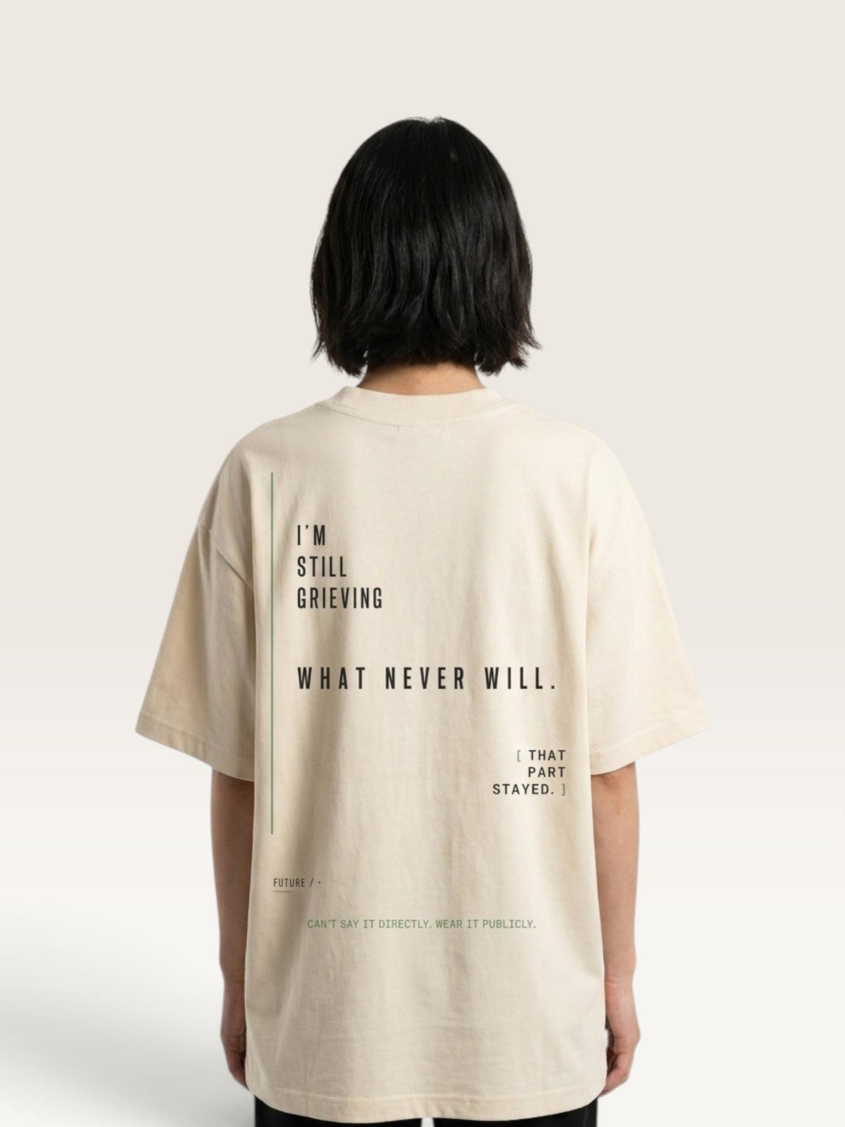WEARCAPTION oversized beige heavyweight cotton t-shirt with black text graphic on the back, worn by a person.