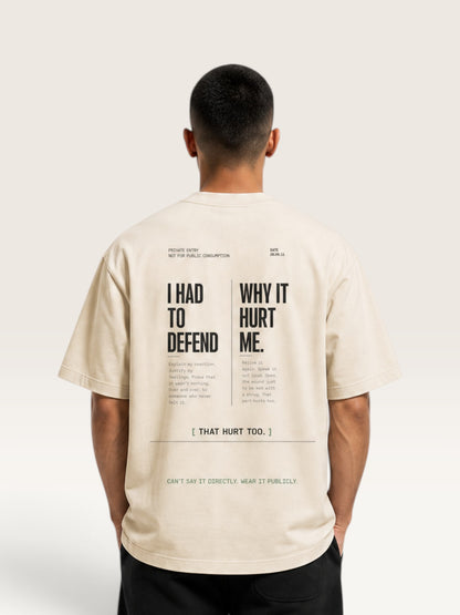 Mild Apricot WEARCAPTION beige heavyweight cotton oversized t-shirt with black graphic text on the back, worn by a man.