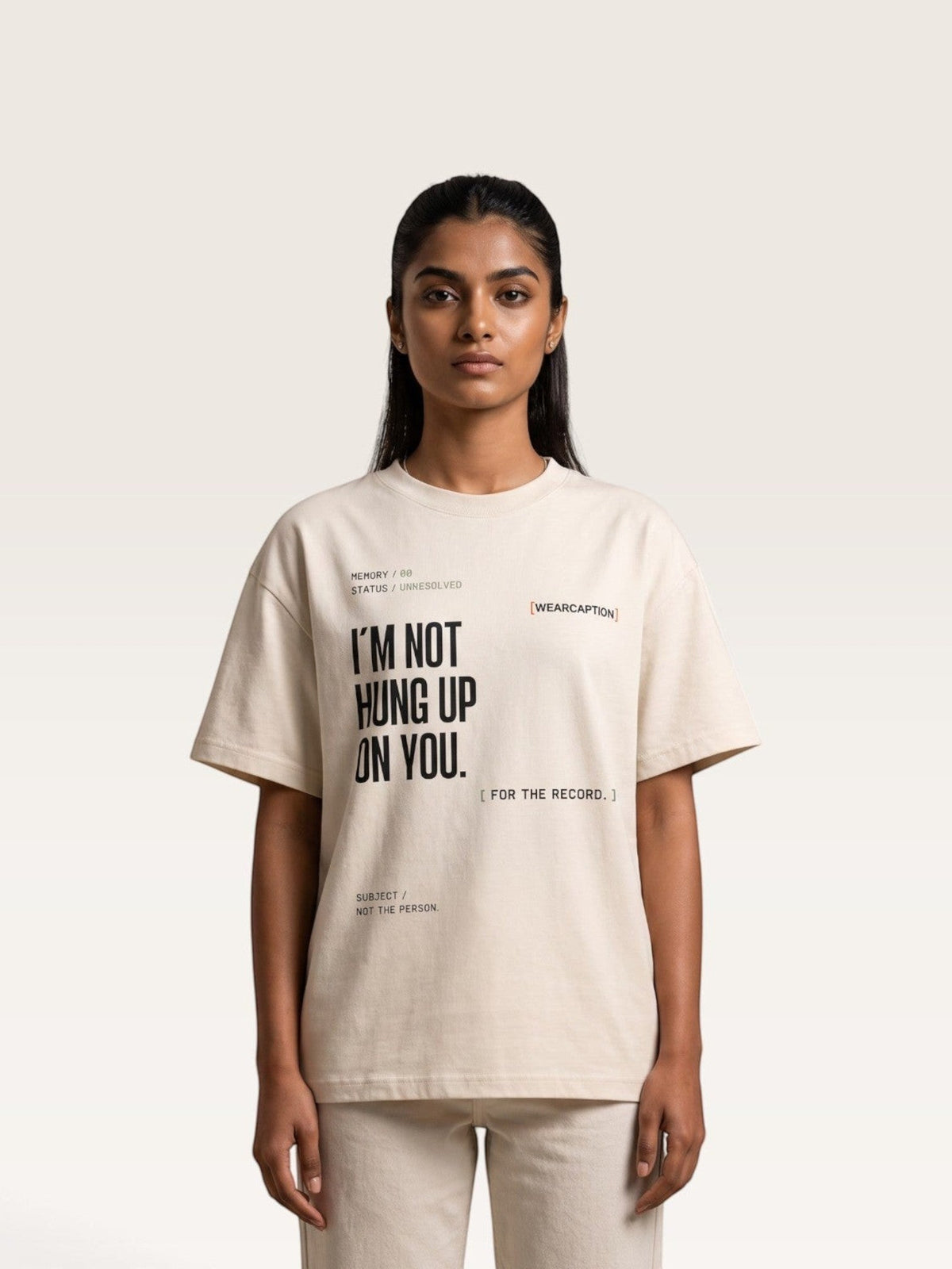 Mild Apricot A model wearing a WEARCAPTION beige heavyweight cotton oversized t-shirt with black graphic text on the front.