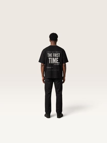 Black WEARCAPTION black heavyweight cotton oversized t-shirt with white graphic text on back, worn by a man in a studio.