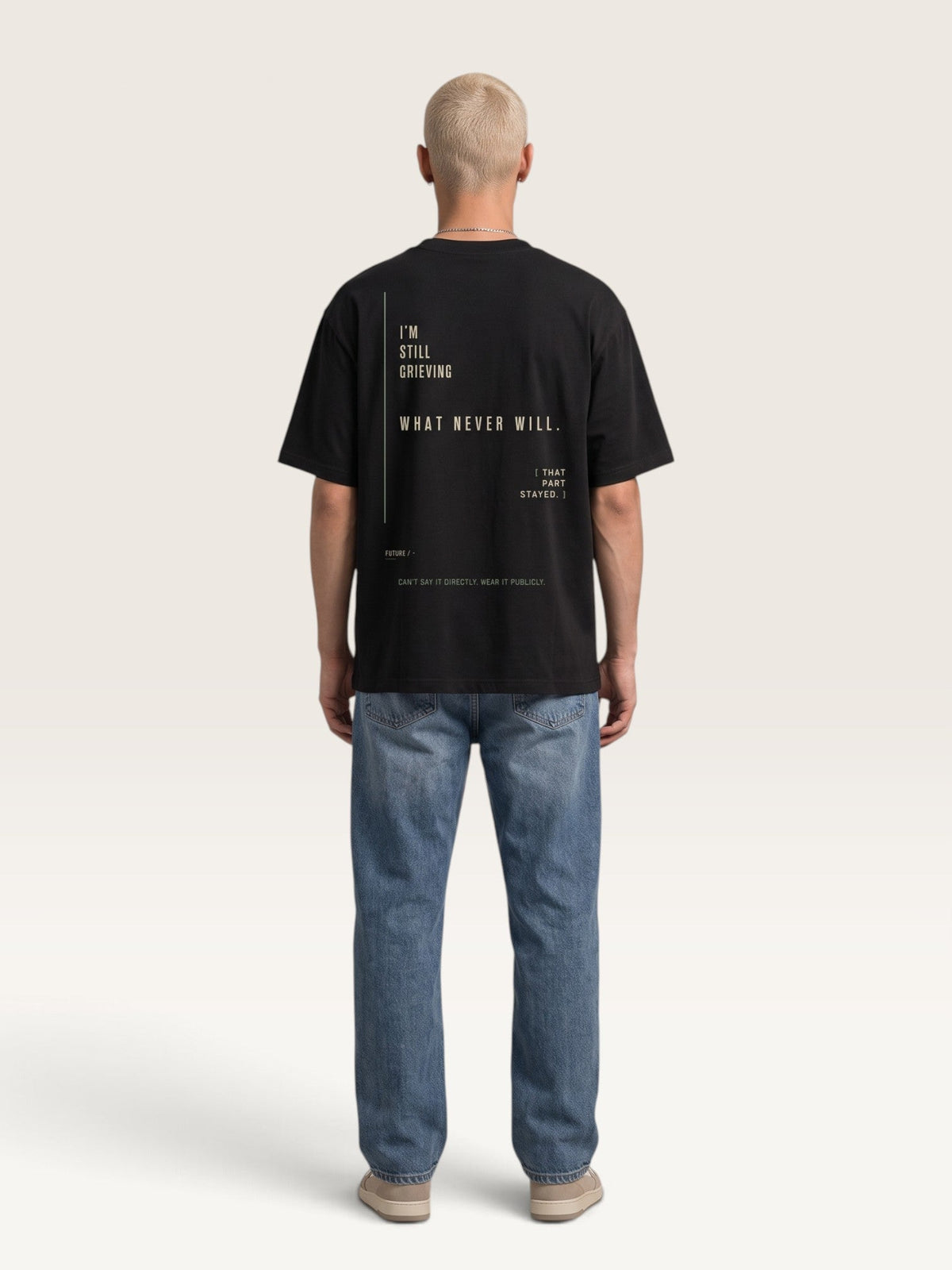 WEARCAPTION black heavyweight cotton oversized t-shirt with white graphic text on the back, worn by a man with jeans.