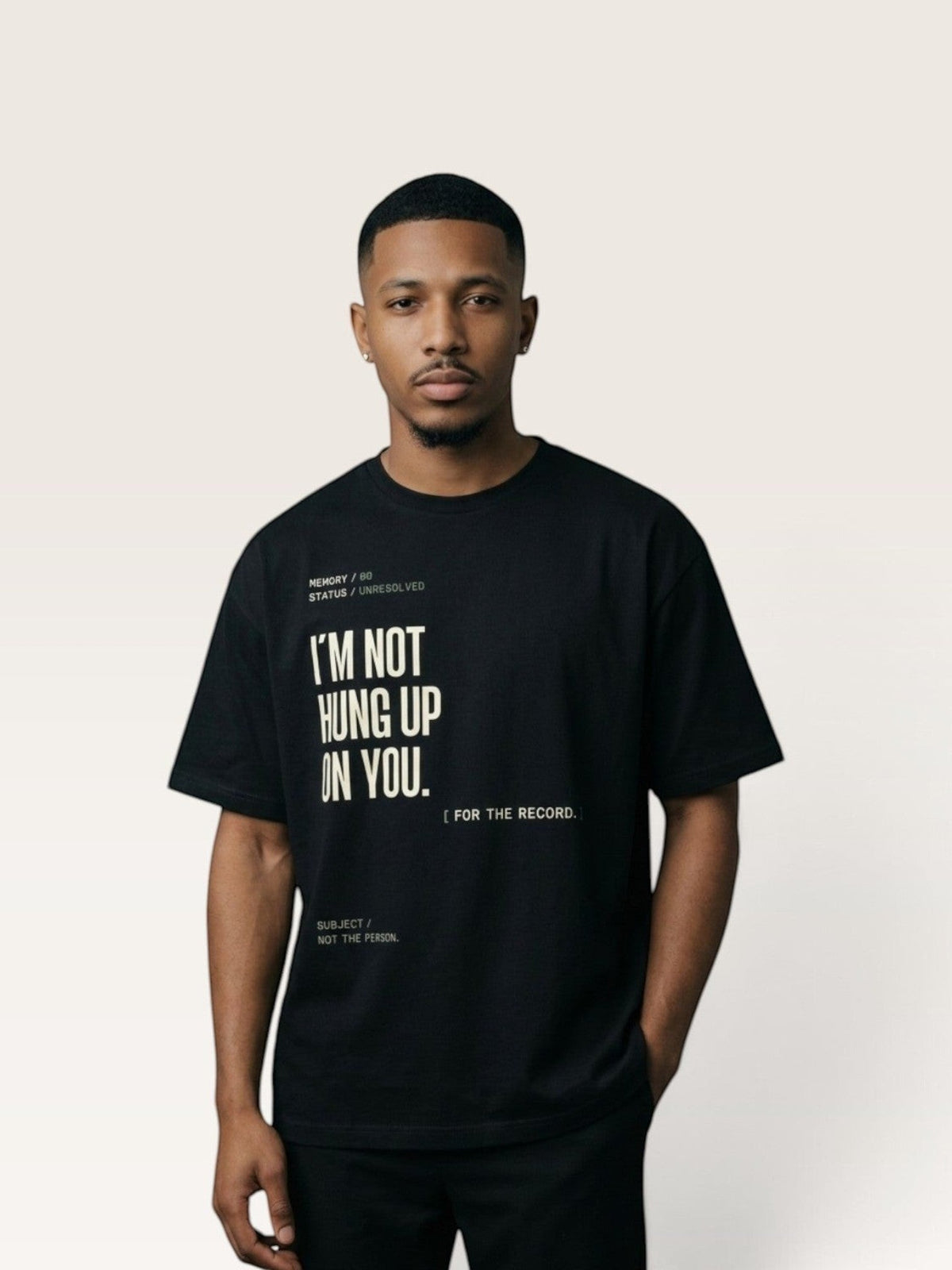 Black  A man wearing a black WEARCAPTION heavyweight cotton t-shirt with white typographic text on the front.