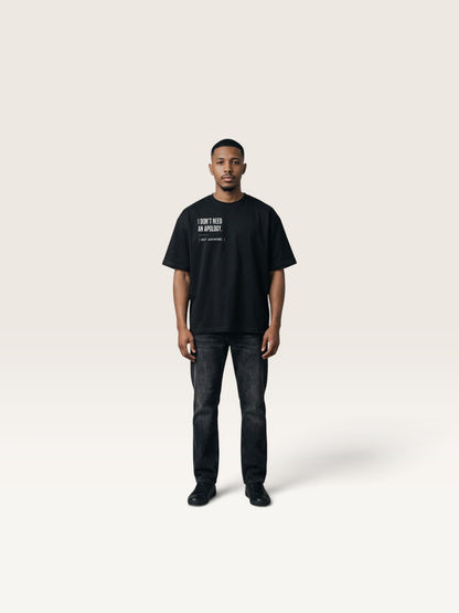 Black WEARCAPTION black heavyweight cotton oversized t-shirt with I DON'T NEED AN APOLOGY text on chest worn by a man