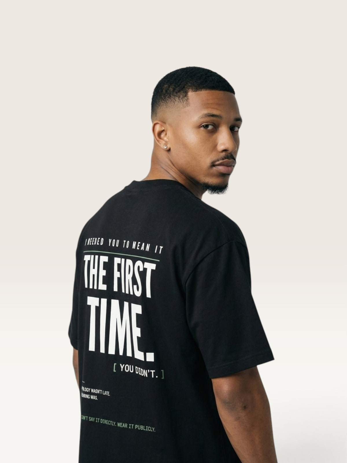 Black WEARCAPTION black heavyweight cotton oversized t-shirt with bold white typography on the back, worn by a man.