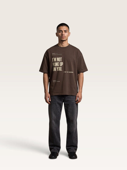 Coffee WEARCAPTION brown heavyweight cotton oversized t-shirt with graphic text print worn by a man with dark jeans