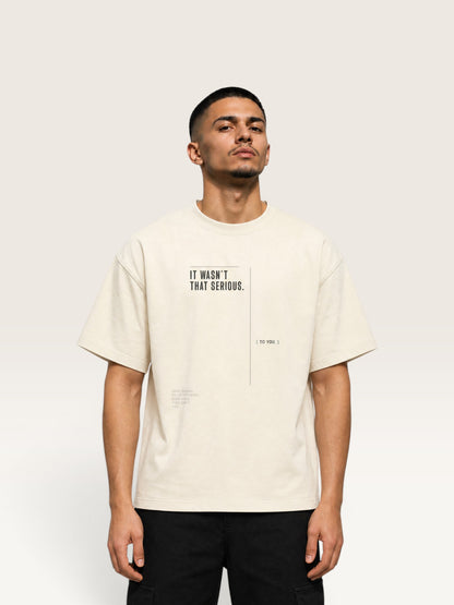 Mild Apricot WEARCAPTION oversized cream heavyweight cotton t-shirt with black graphic text on front, worn by a man.