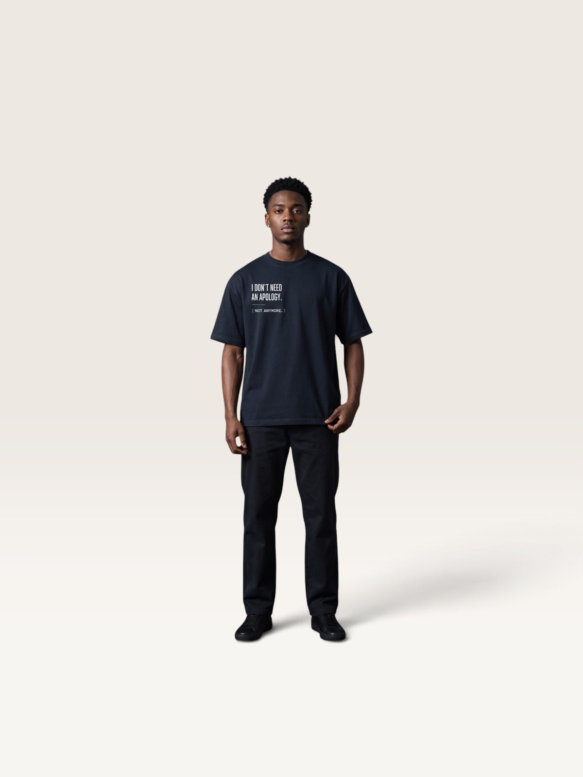 Navy Blue WEARCAPTION heavyweight black cotton oversized t-shirt with white text on the chest, worn by a man against a studio background.