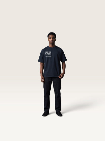 Navy Blue WEARCAPTION heavyweight black cotton oversized t-shirt with white text on the chest, worn by a man against a studio background.