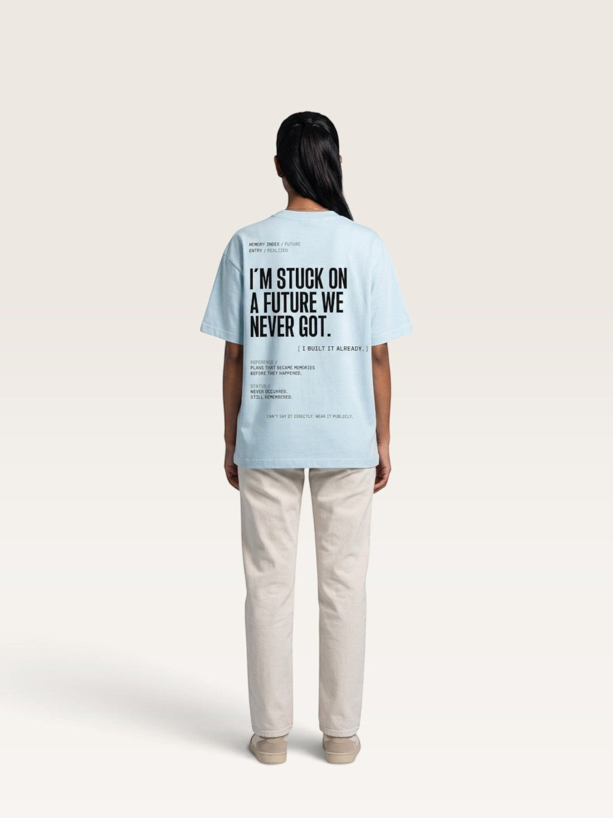 Sky Blue WEARCAPTION light blue oversized heavyweight cotton t-shirt with black graphic text on the back, worn by a woman.