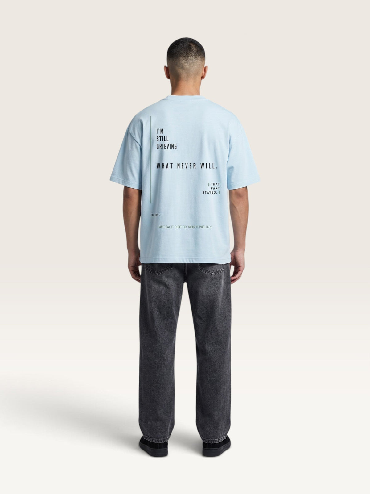 WEARCAPTION oversized light blue heavyweight cotton t-shirt with black typographic print on the back, worn by a man.