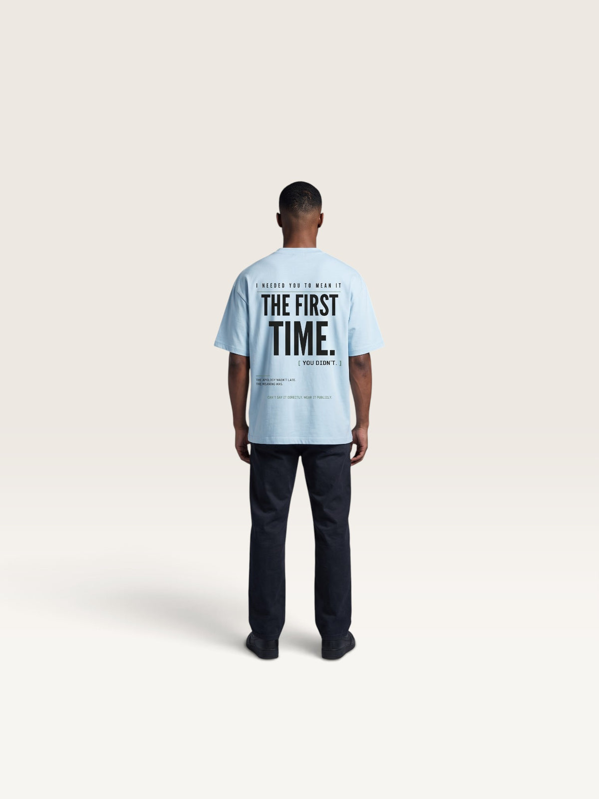 Sky Blue WEARCAPTION light blue heavyweight cotton oversized t-shirt with bold black typography on the back, worn by a man.