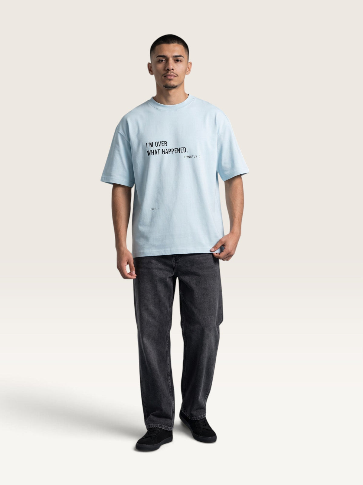 Model wearing a WEARCAPTION light blue heavyweight cotton oversized t-shirt with black text on the chest.