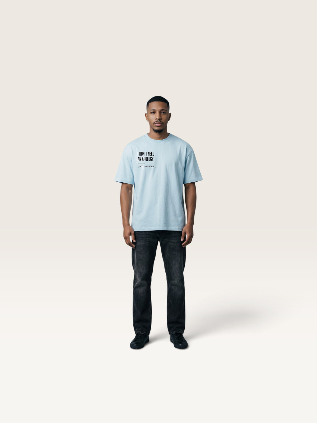 Sky Blue A man wearing a WEARCAPTION light blue heavyweight cotton oversized t-shirt with I DON'T NEED AN APOLOGY text print.