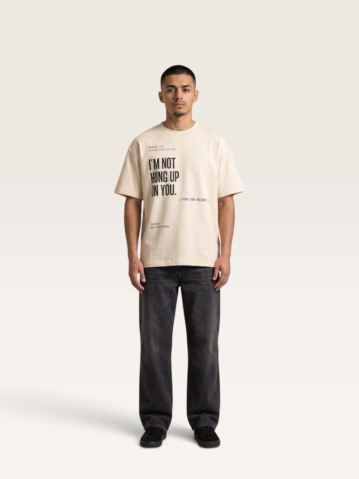 Mild Apricot WEARCAPTION oversized cream heavyweight cotton t-shirt with black text graphic on front, worn by a male model.