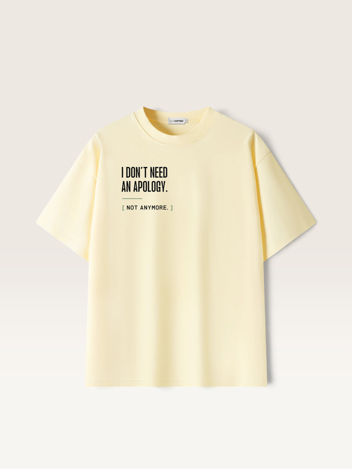 Apricot WEARCAPTION heavyweight pale yellow oversized cotton t-shirt with black text I DON'T NEED AN APOLOGY on the front