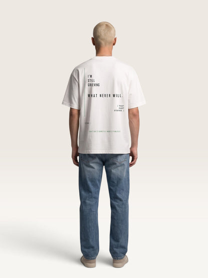WEARCAPTION heavyweight white cotton oversized t-shirt with black typographic print on the back, worn by a man.